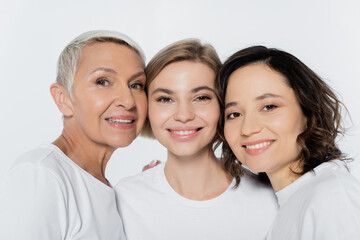 Portrait of positive women looking at camera isolated on grey.