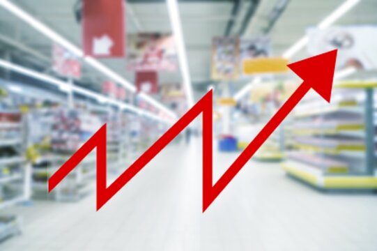 Red growing up arrow on abstract blur image of supermarket background. Bar charts and graphs.