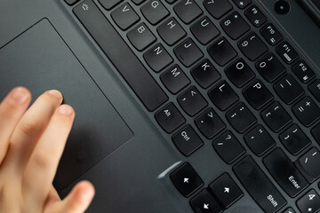 Young girl is typing on the keyboard. Risky behaviour of children in internet. 