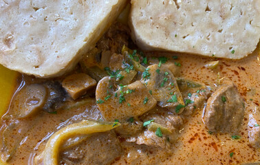 Beef stroganoff with mushrooms, pickles, sour cream and served with brad dumpling slices. Traditional, Russian dish and haute cuisine. Boeuf Stroganoff.