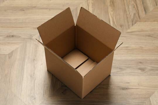 One empty open cardboard box on floor