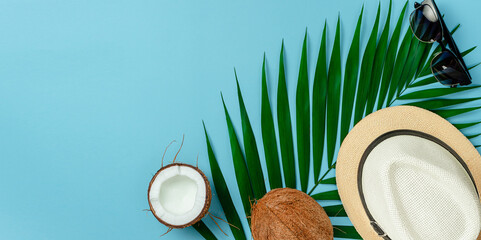 Fototapeta na wymiar Summer background concept. Hat, sunglasses and coconut on blue background. Flat lay, copy space.
