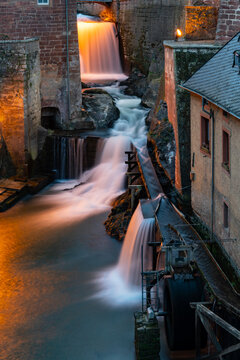Saarburg in Rhineland-Palatinate near Trier, Luxemburg and Saarbrucken is a small touristic town on River Saar with medieval centre and waterfall drop used for mills. Blue hour atmosphere with lights.