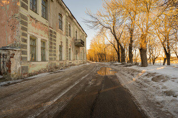 An old, abandoned building. Spring day, puddles on the streets