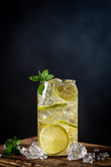 Summer drink green Iced tea with lemon slices and mint on dark background