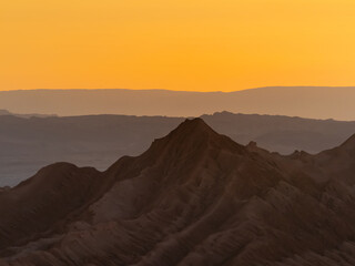 Stunning sunset in the Valle de la Luna (Valley of the Moon), San Pedro de Atacama, Chile. Amazing rock formations, deep canyons and cliffs, huge sand dunes with infinite color and texture variations.