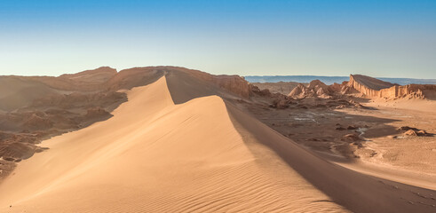 Fototapeta na wymiar Stunning desert landscapes in the Valley of Moon (Valle de la Luna), San Pedro de Atacama, Chile. Unique rock formations, cliffs sand dunes with infinite color and texture variations.