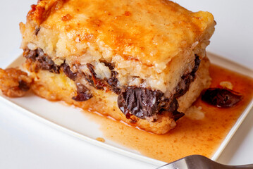 Rice plum pudding with sauce,plate,fork.