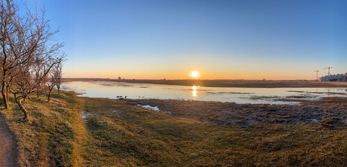 Panoramica de atardecer con lago y sol en fondo