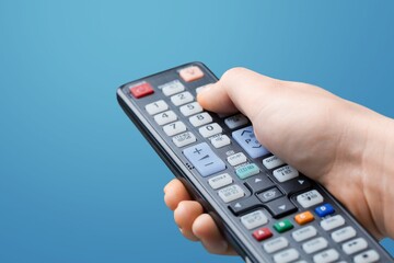 Manage home appliances, elements of a smart home with remote control. The control panel is in a hand.