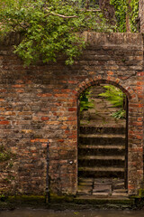 The old brick houses in Bruges. Bruges, Belgium. The old brick wall with archway in a house. 