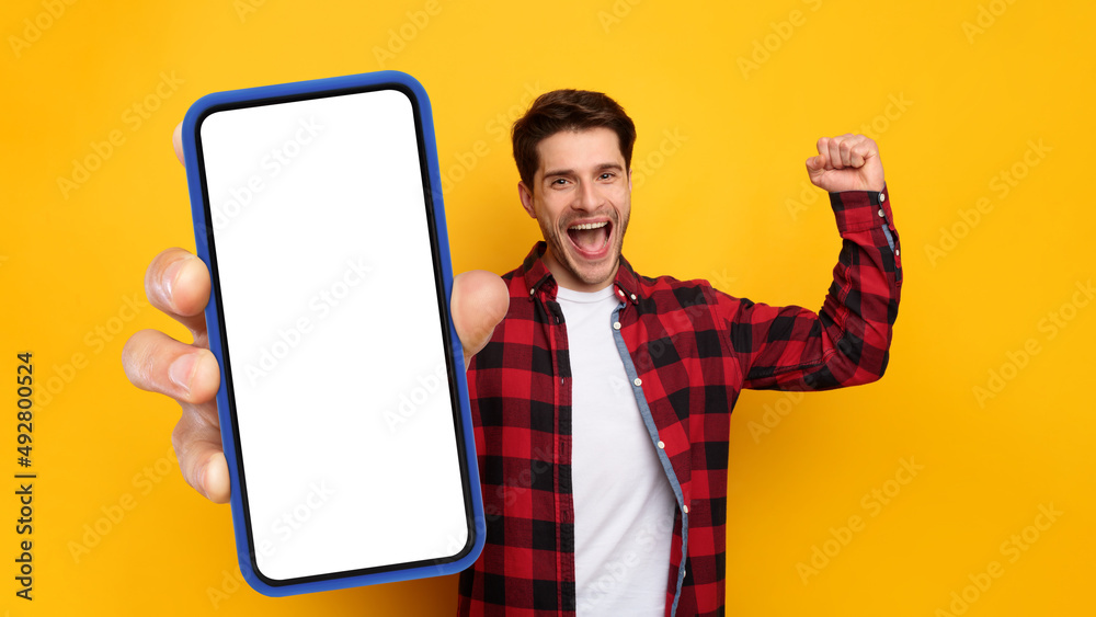 Poster Cheerful guy showing empty smartphone screen gesturing yes