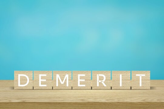 DEMERIT; Wooden blocks with text of concept.