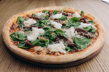 A baked Italian dish consisting of flattened bread dough covered variously with herbs, fresh vegetables, or, typically in the U.S., with tomato sauce, grated cheese, and, often, sausage, mushrooms, pe