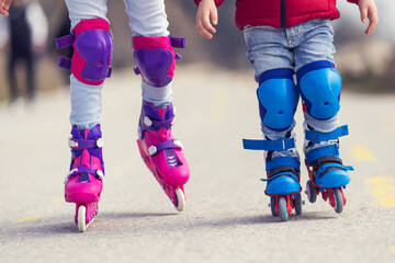 Kids boy and girl having fun outdoor while riding roller skates. Children on rollerblades. Roller...