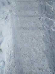 Asphalt path with melted snow close-up