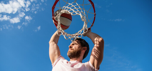 basketball player throws the ball into the hoop outside, sport hobby © Olena