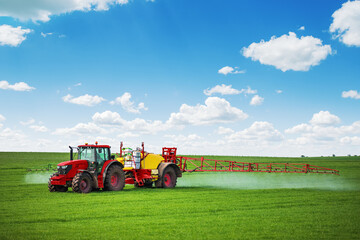 Tractor spray fertilizer spraying pesticides on green field, agriculture background concept.