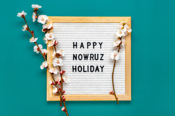Sprigs of the apricot tree with flowers and Text Happy Nowruz Holiday Concept of spring came Top view Flat lay Hello march, april, may, persian new year	