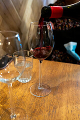 Pouring of dry Italian primitivo red wine in glass in Italian cantina restaurant in Puglia