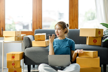 Asian woman owned business SME entrepreneur of Young Asian women working with Boxs laptop and phone for Online seller shopping at home, online marketing packaging delivery SME e-commerce concept