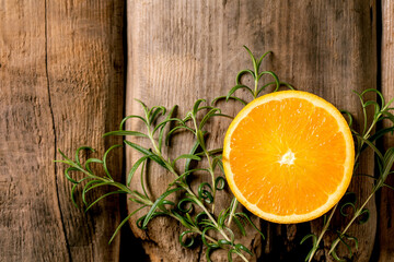 Fresh organic sliced orange and rosemary branches