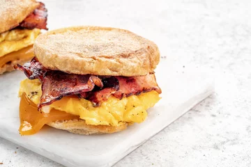 Foto op Aluminium English muffin, egg, ham, and cheese breakfast sandwich on a cutting board © azurita