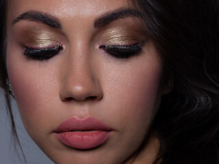 Naklejka premium Close-up portrait of sexy european young woman model with classic glamour make-up and nude lipstick. Dark long hairstyle, christmas makeup, dark eyeshadows, natural pink lips with gloss