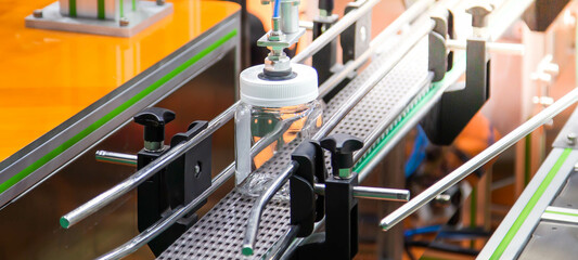 Robot lifting food jar to conveyor belt on production line in food industry