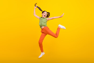 Fototapeta na wymiar Photo of adorable shiny student girl wear green shirt smiling jumping high running fast isolated yellow color background