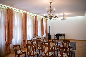 Concert or presentation hall room with row of old soft comfortable vintage chairs and expensive carved furniture. Luxurious vintage interior. Empty auditorium.