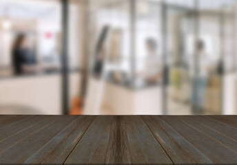 Wooden board empty table top on of blurred office background.