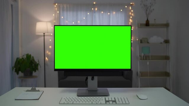 Green screen desktop set on table. Empty living room with modern chroma key green screen mock up computer set up for online videocall meeting. Pc with isolated display in home office