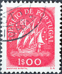 Portugal - circa 1943: a postage stamp from Portugal, showing a historical Caravel with sails from the 15th Century . red