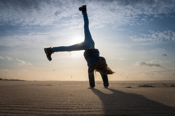 Girl doing a cartwheel on a beach
