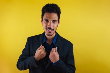 Black man in a suit in the studio isolated on yellow background. Isolated businessman with dramatic light.