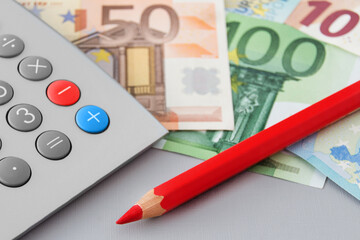 Euro Geldscheine und Rechner mit rotem Stift