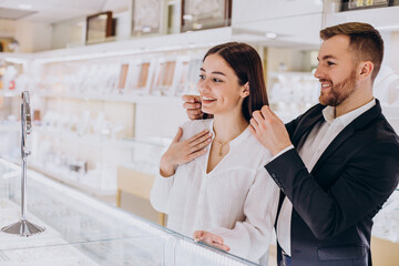 Young couple choosing a necklace at jewelry store