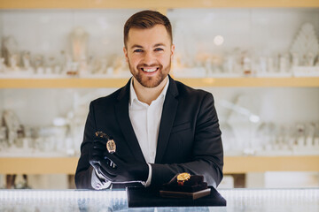 Handsome sales man demonstrating watches at jewelry shop