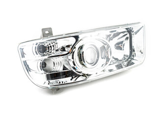 Stylish xenon headlight for truck or pickup - optical equipment with a lamp inside on a white isolated background. Spare part for auto repair in a car workshop. © gargantiopa
