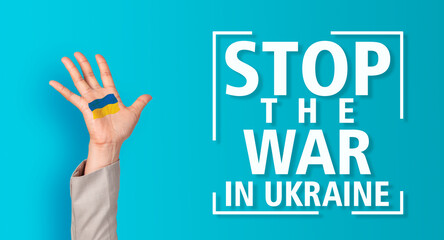 Stop the war in Ukraine Woman showing palm with Ukrainian flag in camera, isolated on blue background.