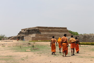 A group of orange dressed monks on a historic temple side in india 