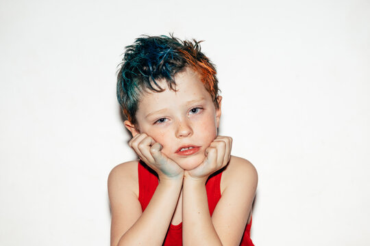 Bored boy with dyed hair looking at camera