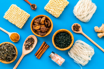 Chinese and Japanese food cooking with ginger, spices and noodles on blue background top view geometric pattern