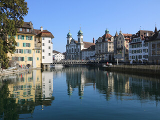 Fototapeta na wymiar Beautiful old buildings reflecting in the Reuss, river in Lucerne, Switzerland.