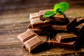 black and milk chocolate bars with mint dark wooden table background