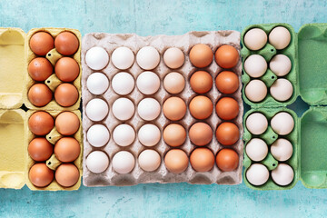Free range organic  chicken eggs in various cardboard colored egg trays. Top view blank space
