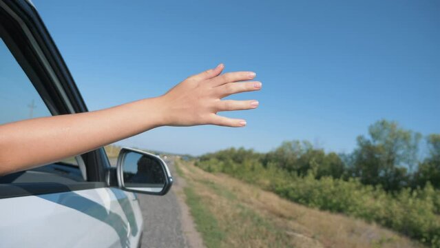 Girl hand in car window. Car trip at sunset. Happy family. Girl hand greeting in car window. Summer family trip at sunset. Family car travel concept. Happy girl hand in window. Family happy vacation.