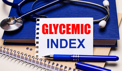 On the table are notepads, a stethoscope, a pen and a sheet of paper with the text GLYCEMIC INDEX. Medical concept
