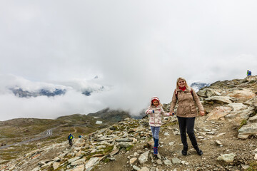 Mother and to children going for a walk in mountain surroundings